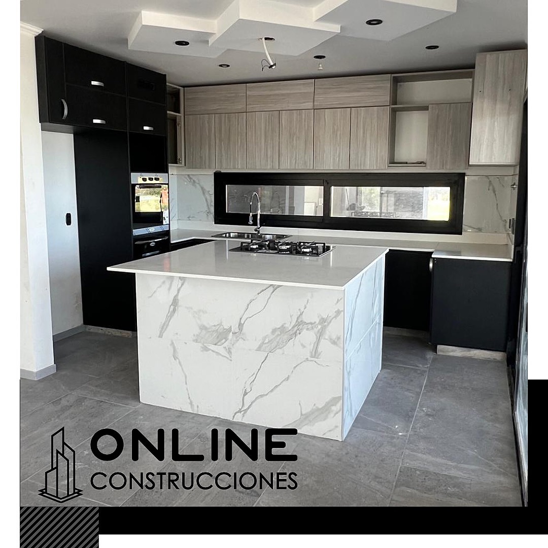 Cocina con isla en porcelanato símil mármol, cielorraso con bajadas de luz y aberturas negras — casa terminada por Online Construcciones
