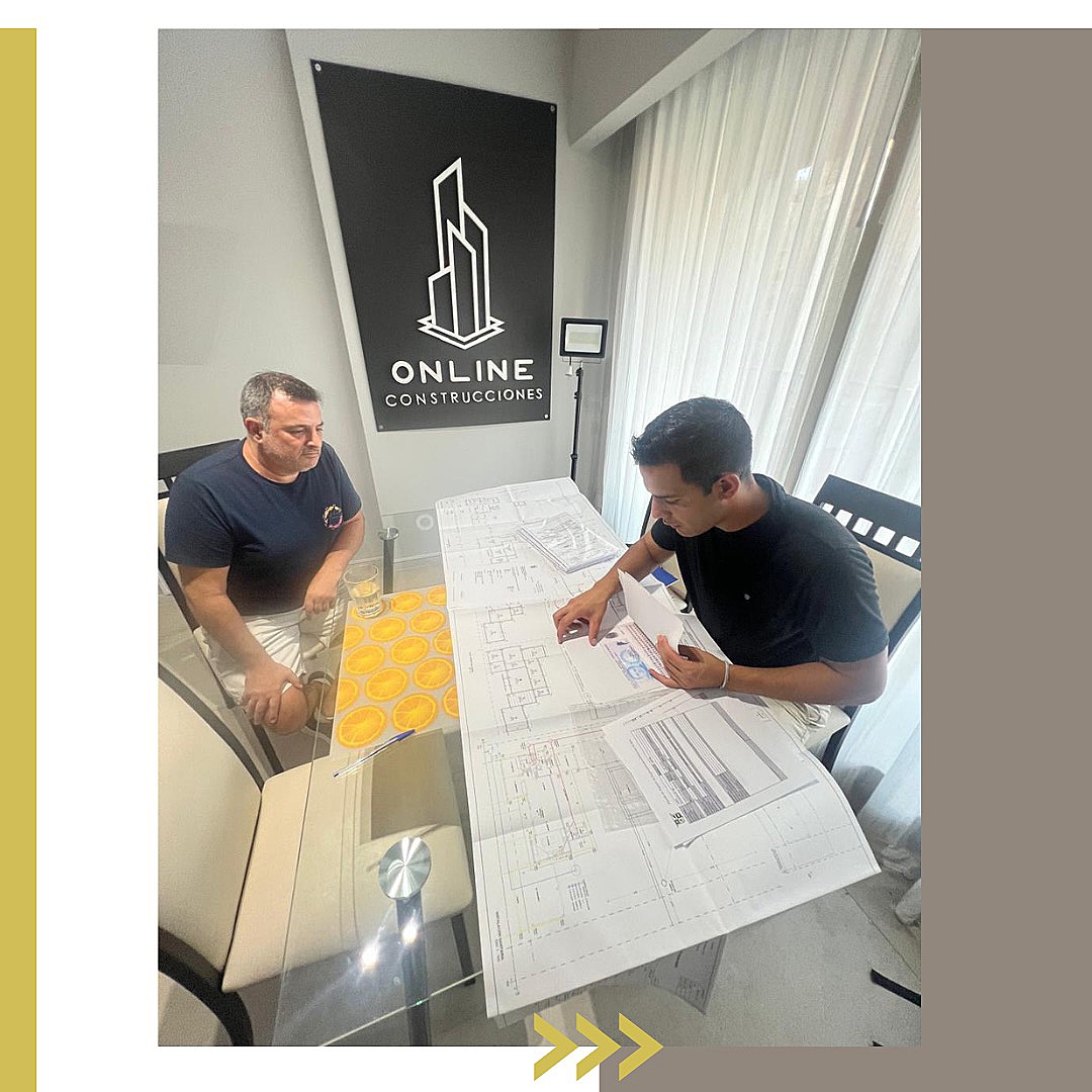 Revisión de planos con un cliente en la oficina de Online Construcciones, Av. Crámer 1745